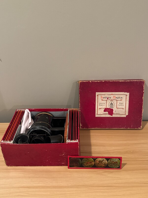 A toy magic lantern set in its red box