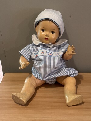 Old doll with a softly worn face and plain construction