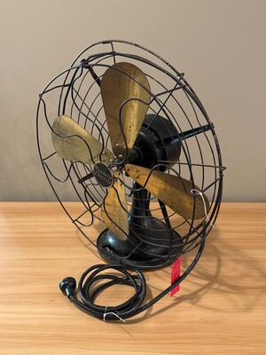 Vintage electric fan with golden metal blades on a sturdy base