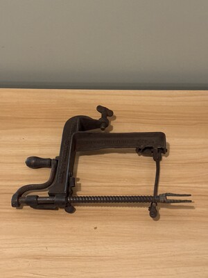 Unidentified metal implement resembling a clamp or small bench tool