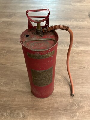 Mid-20th-century fire extinguisher in industrial red