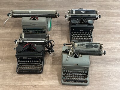Grouping of four vintage typewriters arranged on a wooden surface