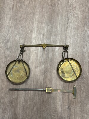Old balance scale with aged brass pans and steel arms