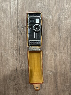 Vintage folding camera resting in its worn leather case