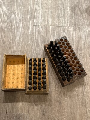Set of vintage steel stamp punches nested in their worn wooden trays